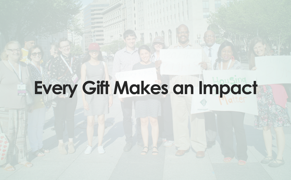 Every Gift Makes an Impact: text on top of a group of people holding pro-housing signs